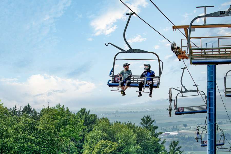 Two friends on the ski lift for biking — Mont Rigaud, ski resort, snowboarding, alpine touring, mountain biking and hiking, family-friendly, in Rigaud Quebec, near Montreal
