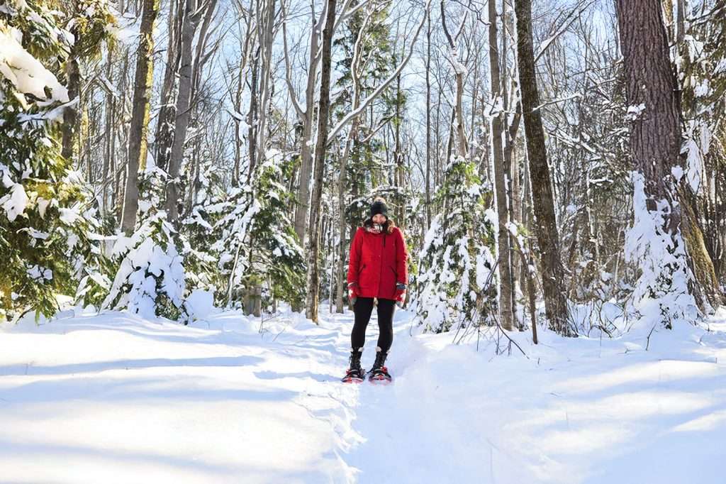 A woman is snowshoeing in a snow-covered field — Mont Rigaud, ski resort, snowboarding, backcountry skiing, mountain biking, and hiking, family-friendly, in Rigaud, Quebec, near Montreal