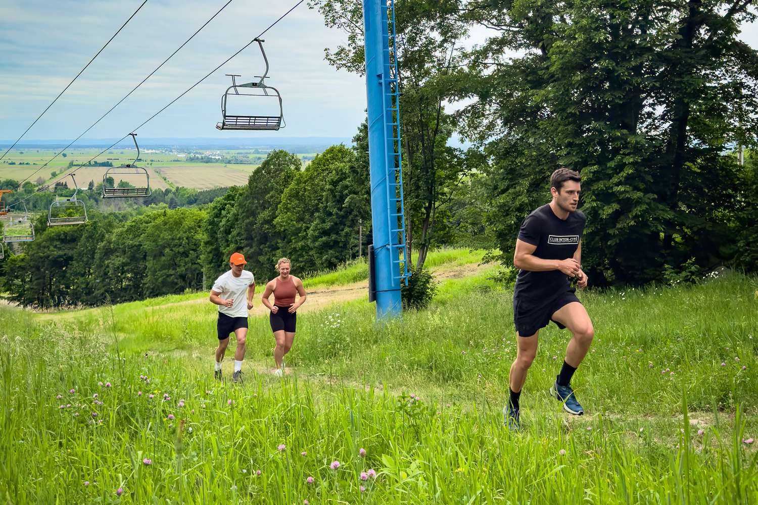 Trois coureurs en sentier montent la montagne de Rigaud Deux amis dans la remontée mécanique pour vélo — Mont Rigaud, station de ski, planche à neige, randonnée alpine, vélo de montagne et randonnée pédestre, familiale, à Rigaud Québec, près de Montréal