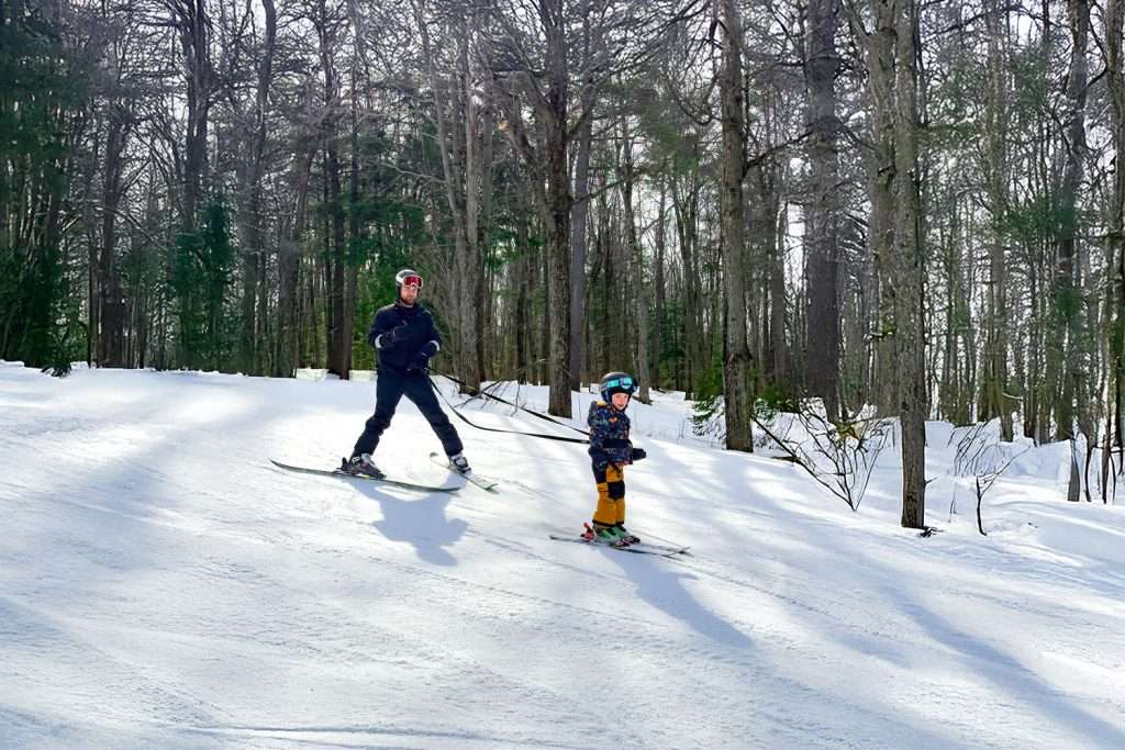 A father teaches his son to ski — Mont Rigaud, ski resort, snowboarding, backcountry skiing, mountain biking, and hiking, family-friendly, in Rigaud, Quebec, near Montreal