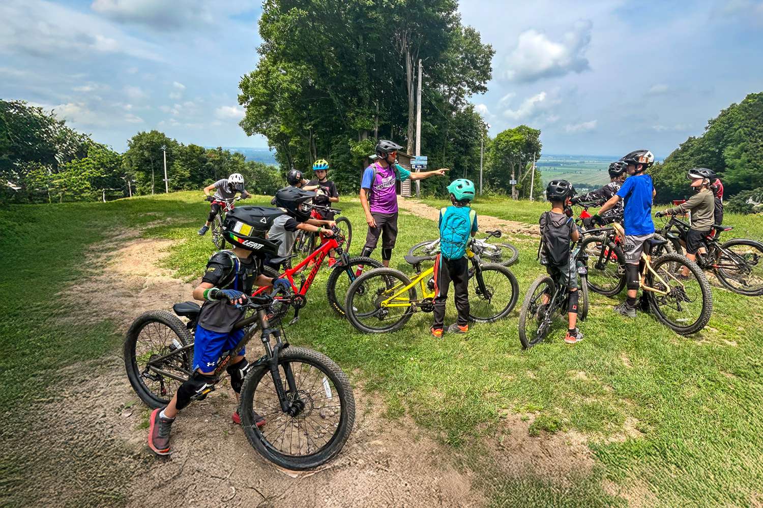 Un instructeur du camp de jour Dirt Camp et son groupe — Mont Rigaud, station de ski, planche à neige, randonnée alpine, vélo de montagne et randonnée pédestre, familiale, à Rigaud Québec, près de Montréal